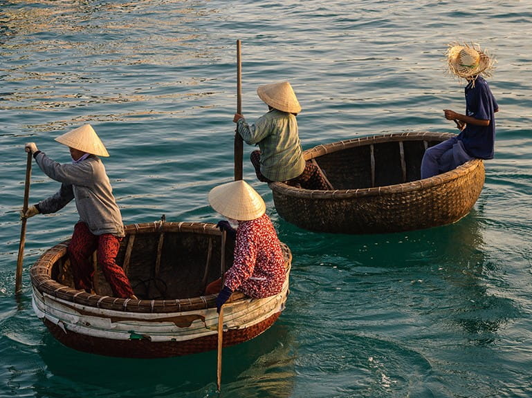 Vietnamese women row in traditional basket boats