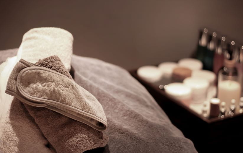 Towel and eye mask laid on a bed ready for a massage to happen