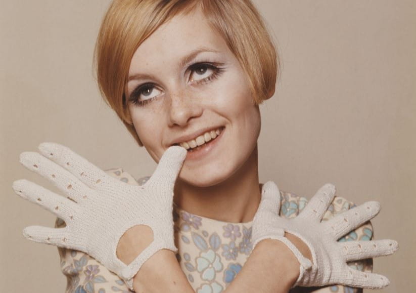 Twiggy when she was a young model with her hands in front of her face