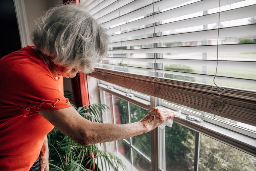 Woman cleaning her blinds