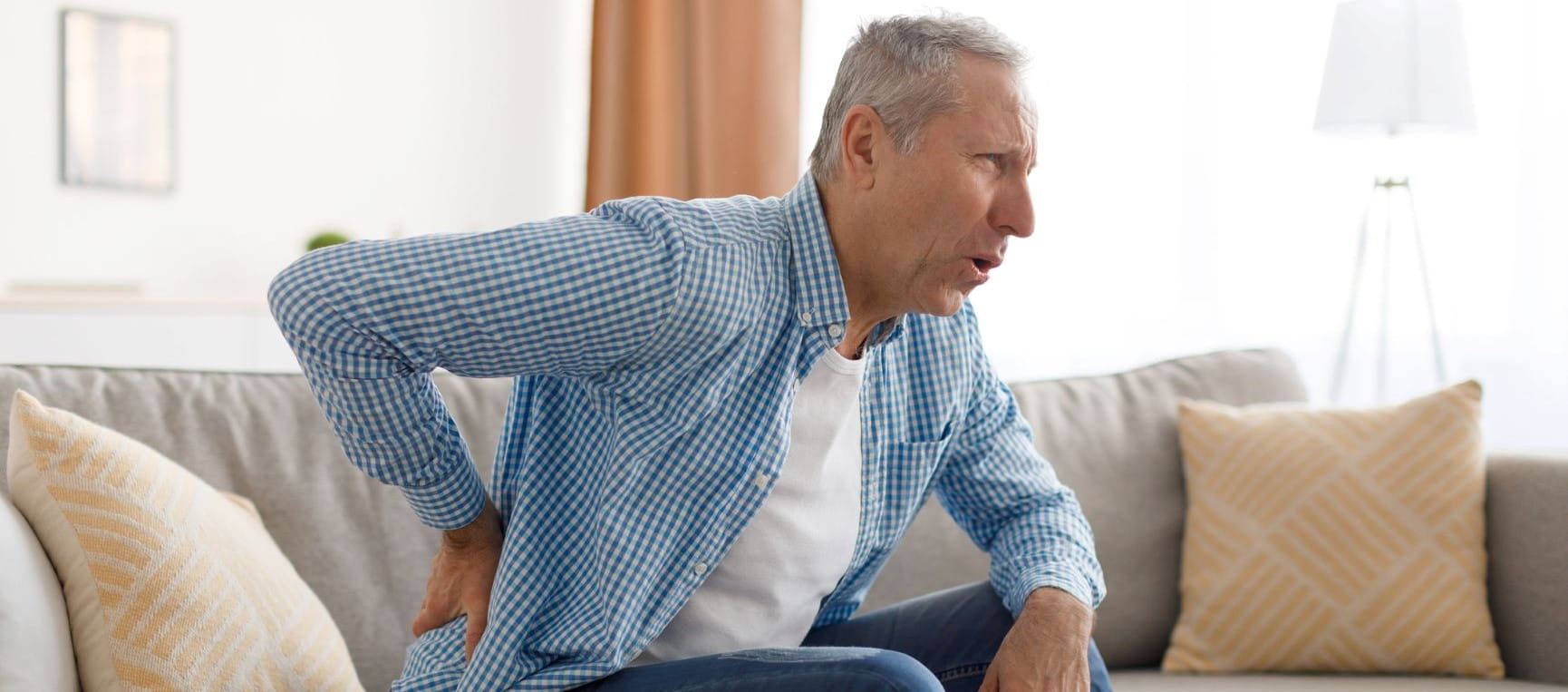 Man holding his back in pain with sciatica
