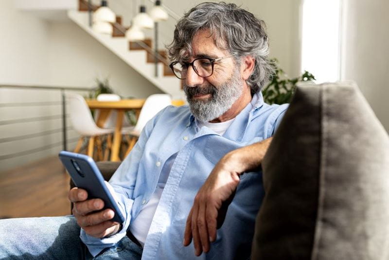 Man playing on his phone in his lounge