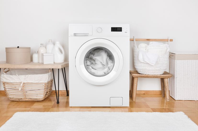 Washing machine in a laundry with a white wash