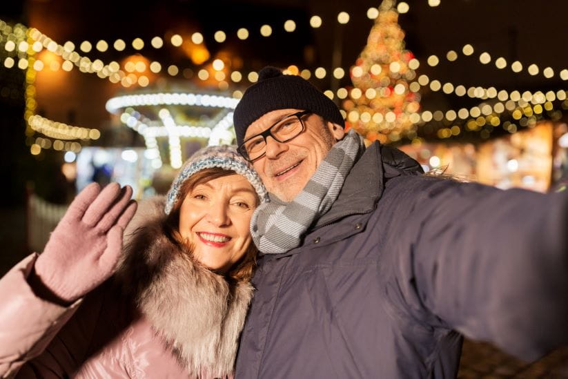 Couple taking a selfie with fairy lights in the background