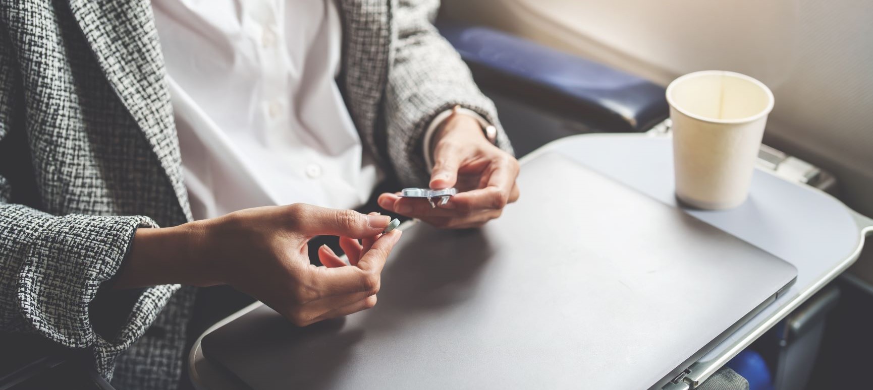 woman taking prescription drugs on an aeroplane