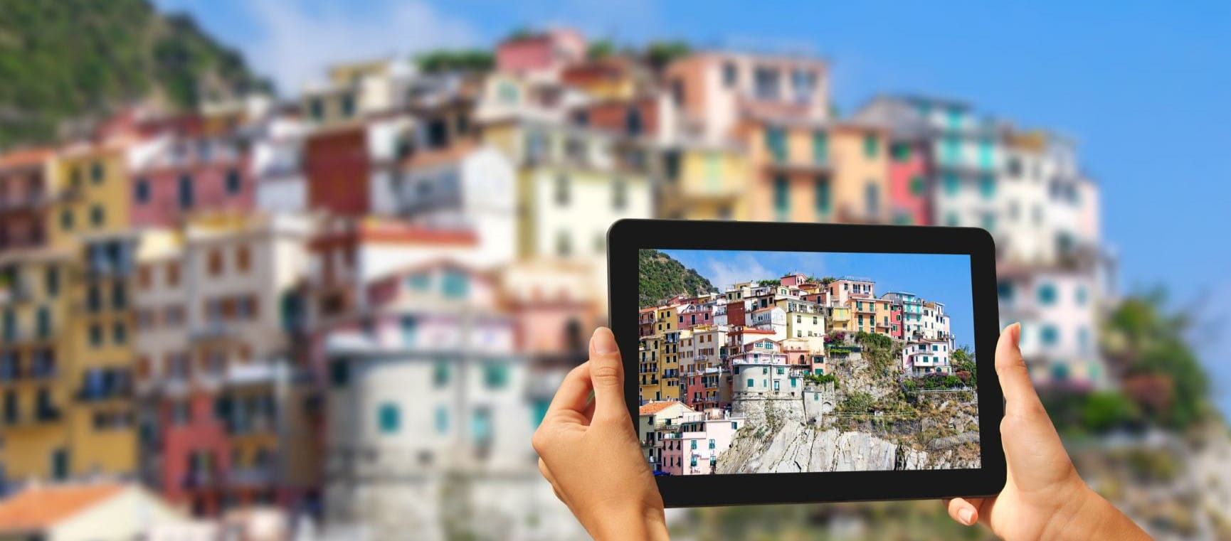 Someone holding up an iPad to an Italy village to take a photo