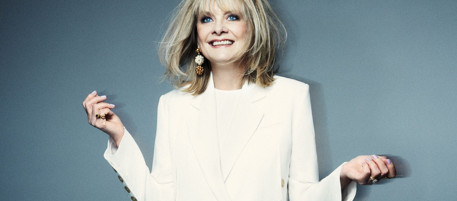 Twiggy in the wind in a studio posing wearing white