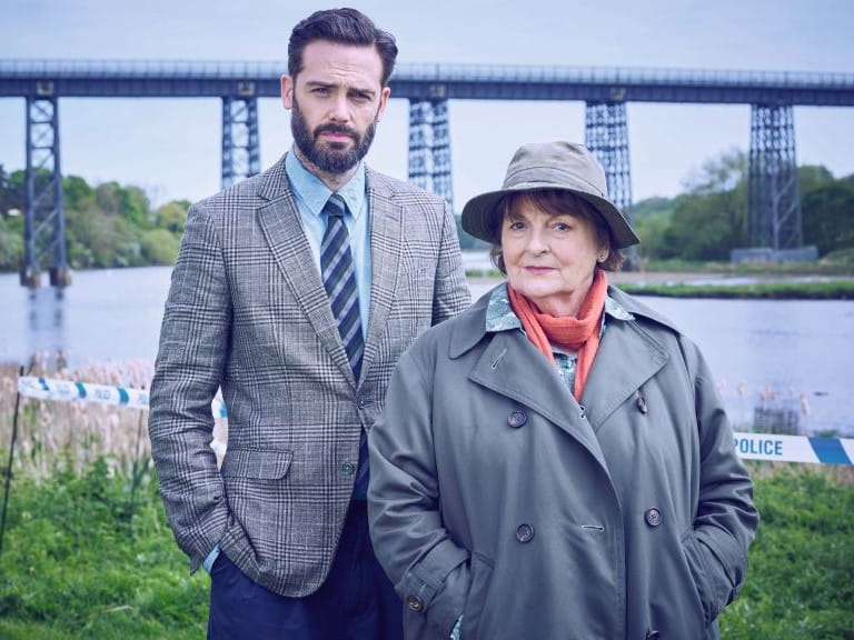 TV character Vera and her sidekick Joe in front of a bridge