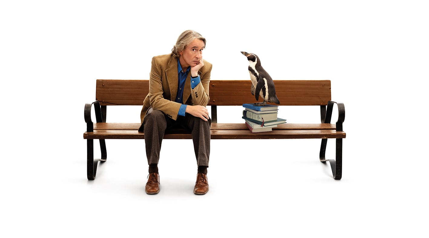Steve Coogan sat on a bench for the film