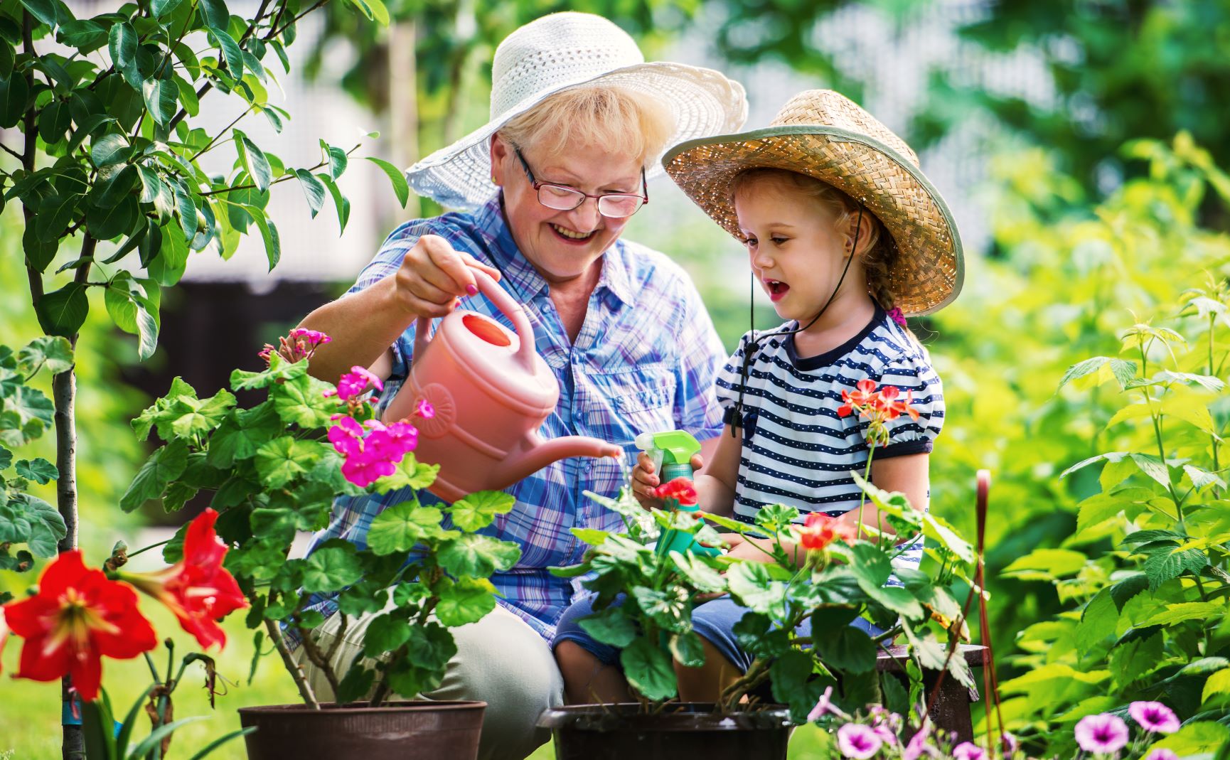 kid watering plants with grandma