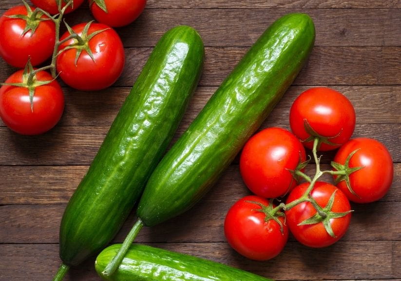 tomatoes and cucumbers on a wooden surface