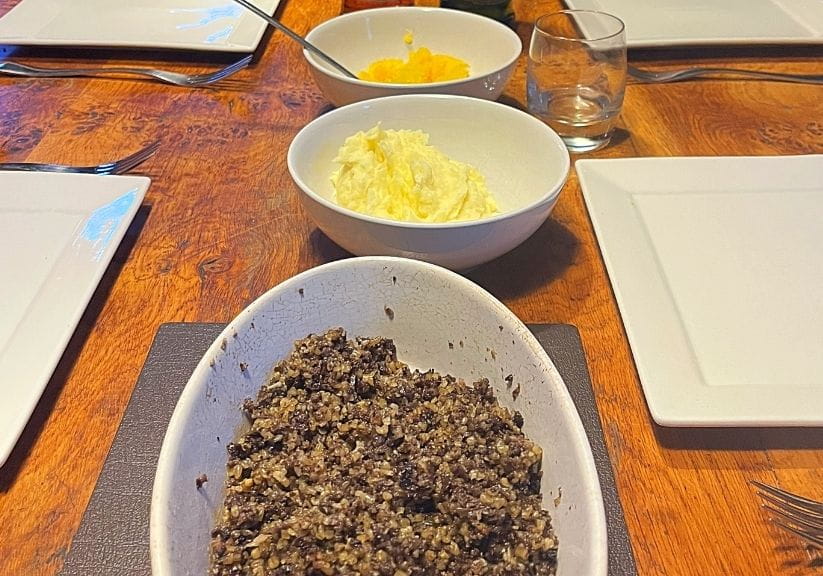 Cooked Macsween haggis on a table with traditional 'neeps and tatties'