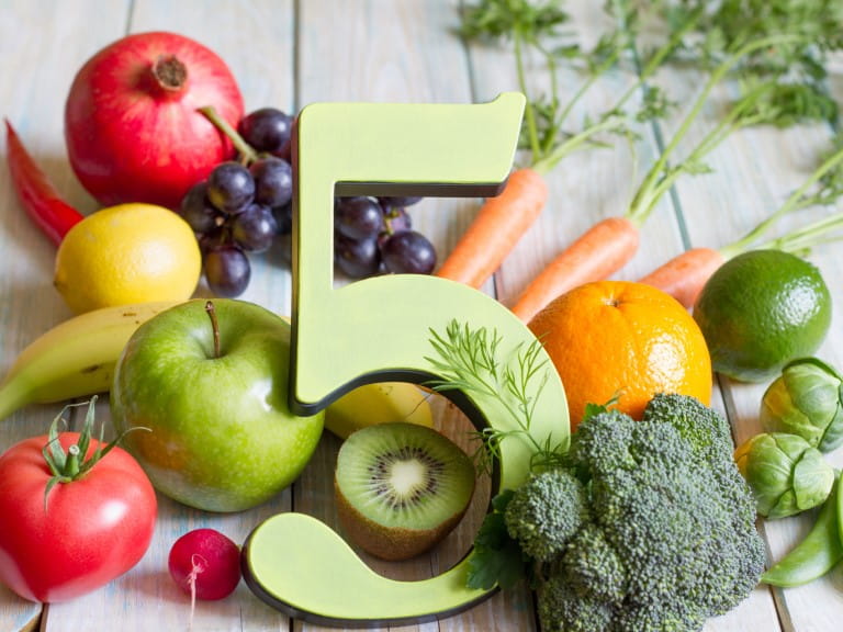 An assortment of fruit and veg surrounding the number 5