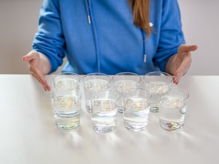Eight glasses of water on a table