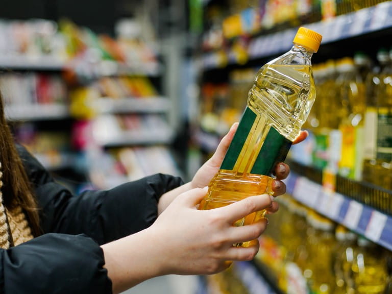 A bottle of Sunflower oil being bought in a supermarket
