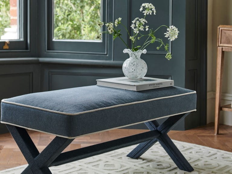  a wooden bench with a dark cushion