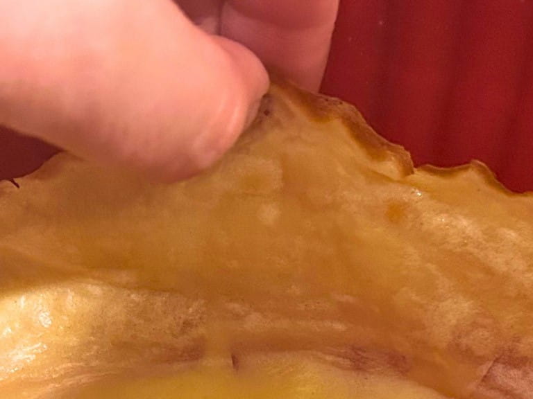 Fingers picking up the edge of a pancake