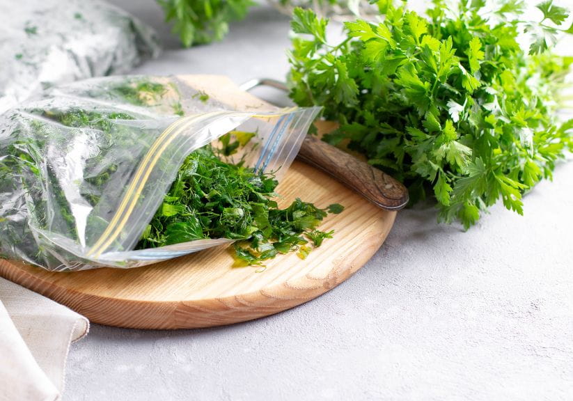 Herbs sat on a chopping board in a plastic bag before being put in the freezer