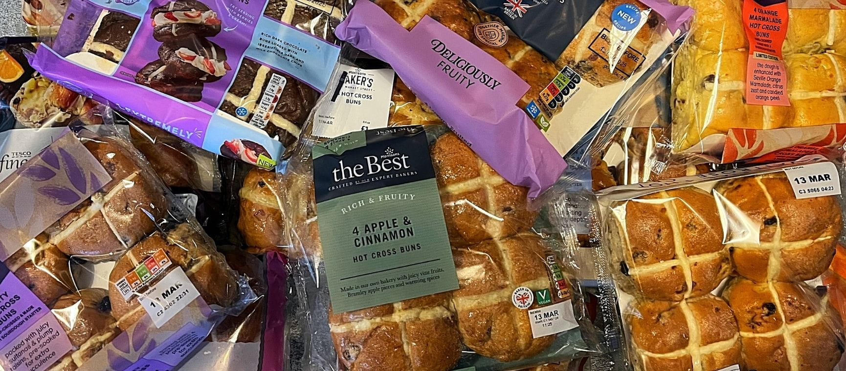 lots of packets of supermarket hot cross buns