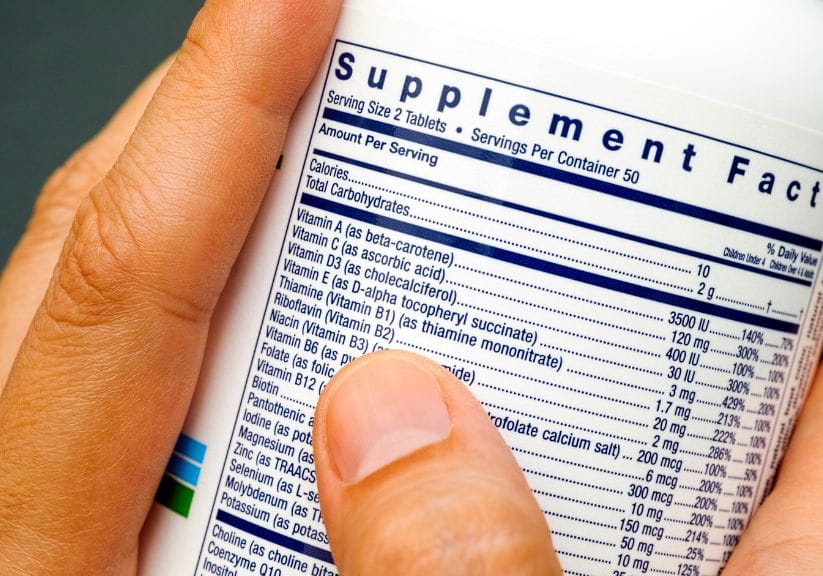 Someone looking at supplements on a bottle