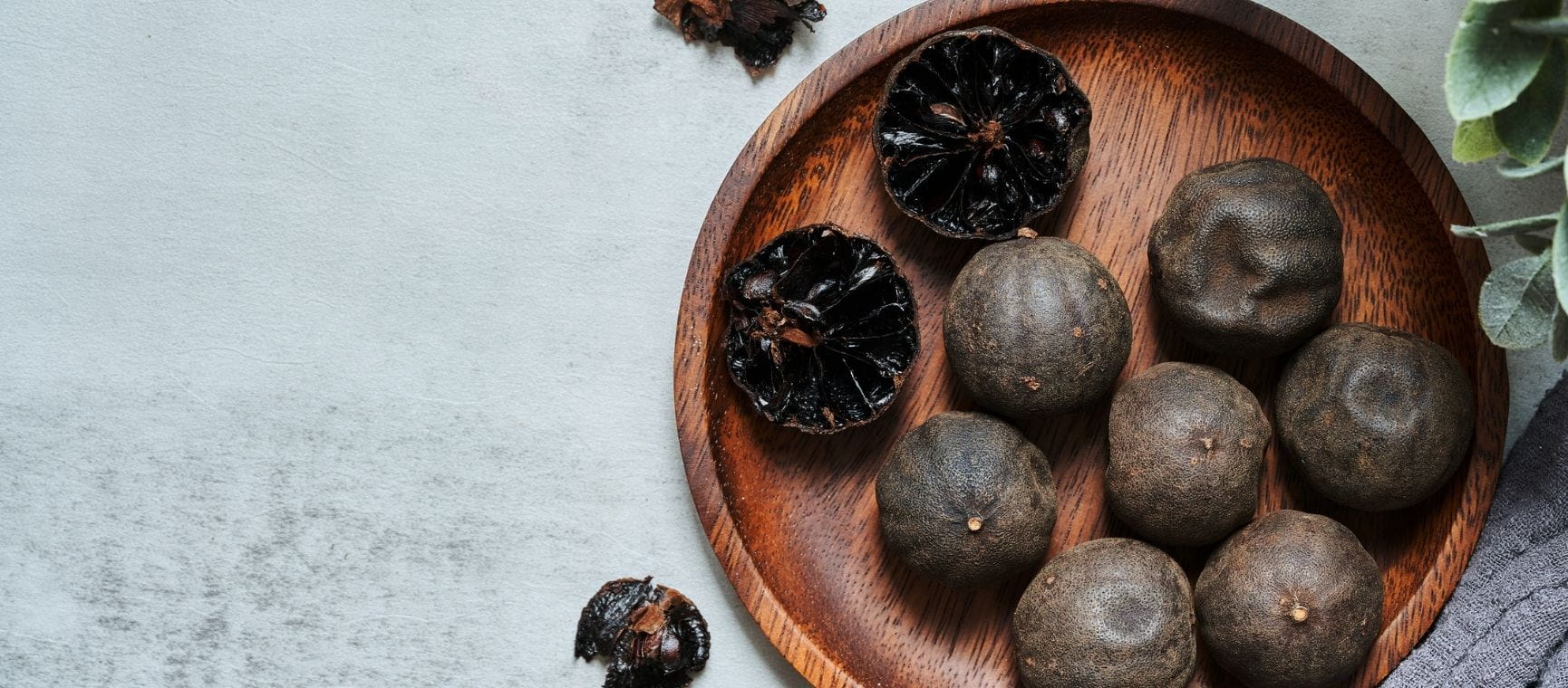 a bowl containing black limes on a white tablecloth