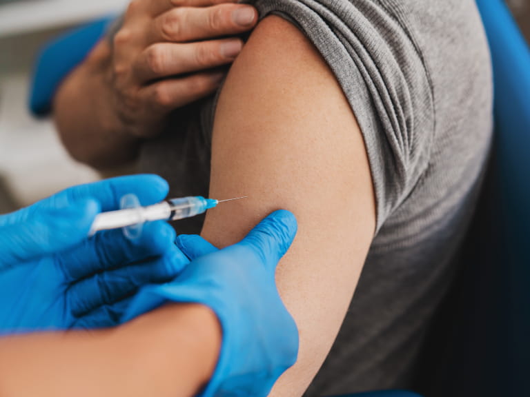 Doctor giving an injection to older people patient in clinic