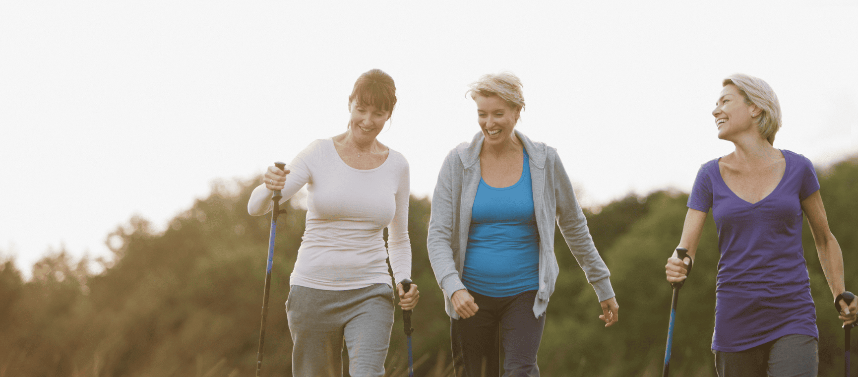 three friends laughing and walking together outdoors