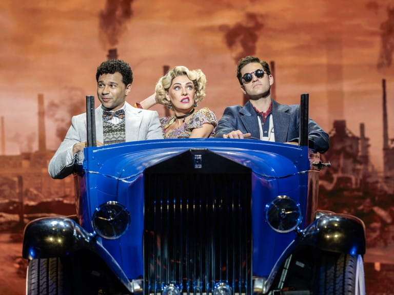 Corbin Bleu, Rachel Tucker, and Jon Robyns in a blue car on-stage