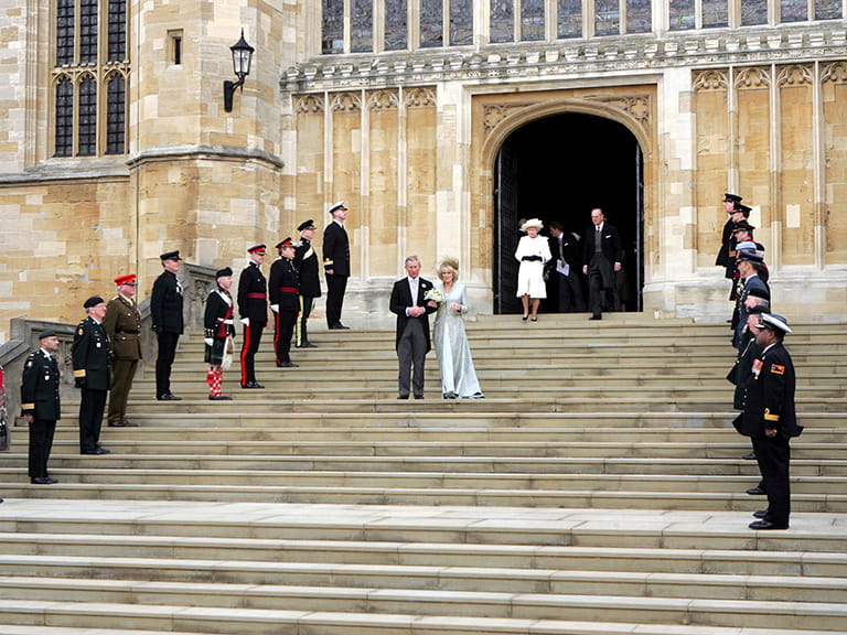 King Charles and Camilla at their wedding walking down the church stairs