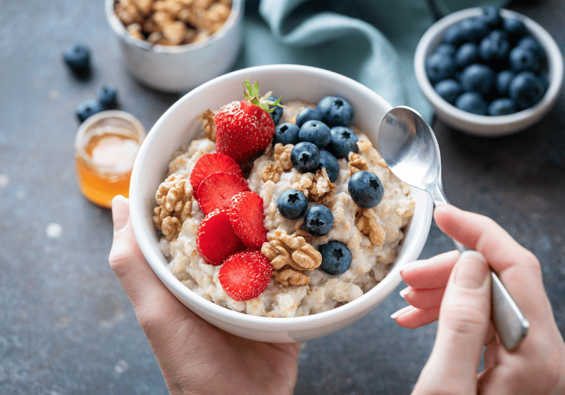 a bowl of porridge topped with blueberries and walnuts