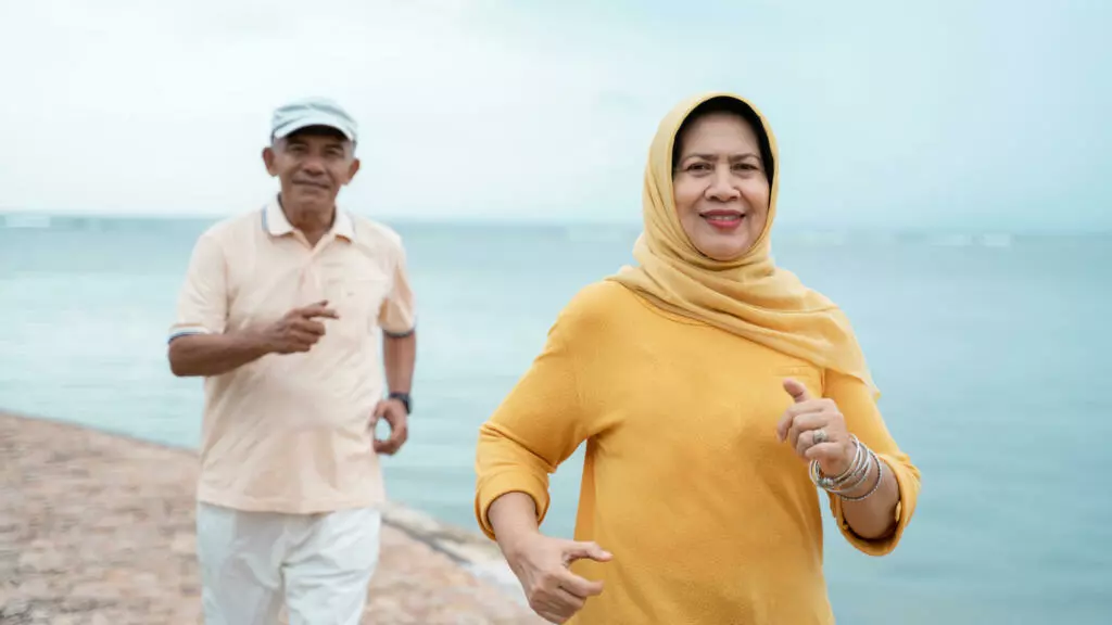 Two people running along a shoreline
