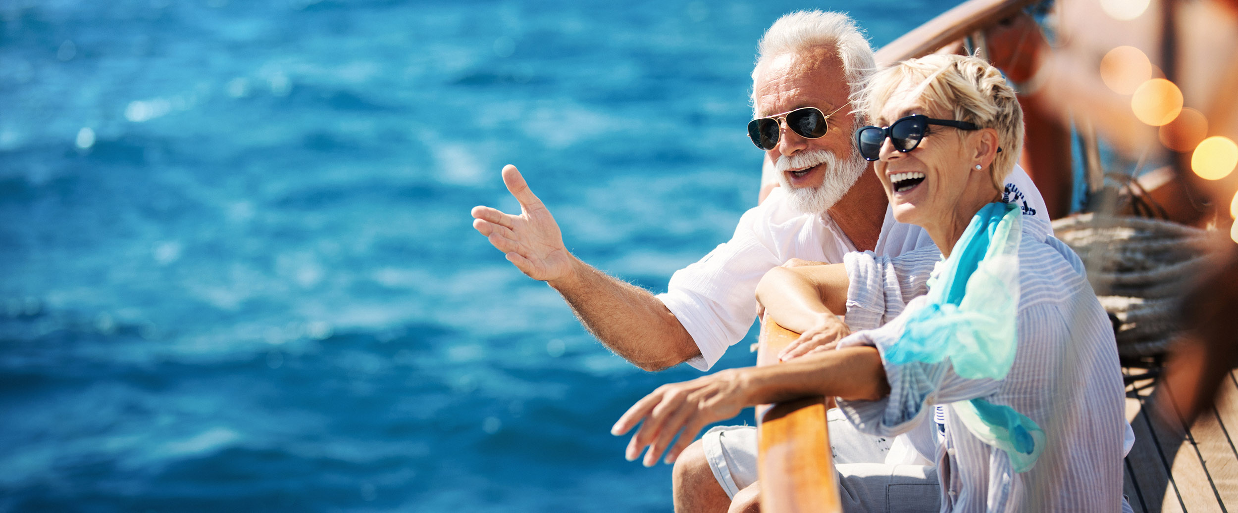 An older couple on a boat in the sunshine