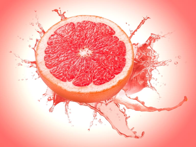 Half a grapefruit on a pink background