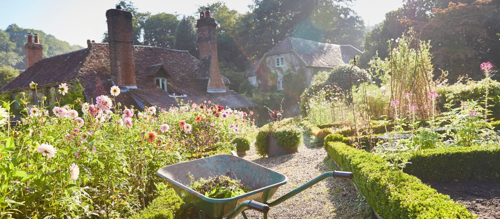 a beautiful UK country garden with a wheelbarrow