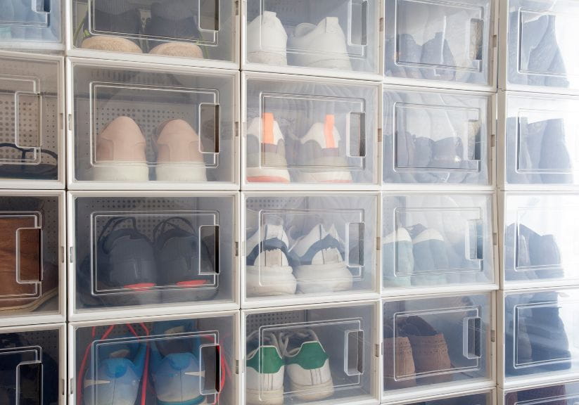 A row of shoes stored in plastic boxes