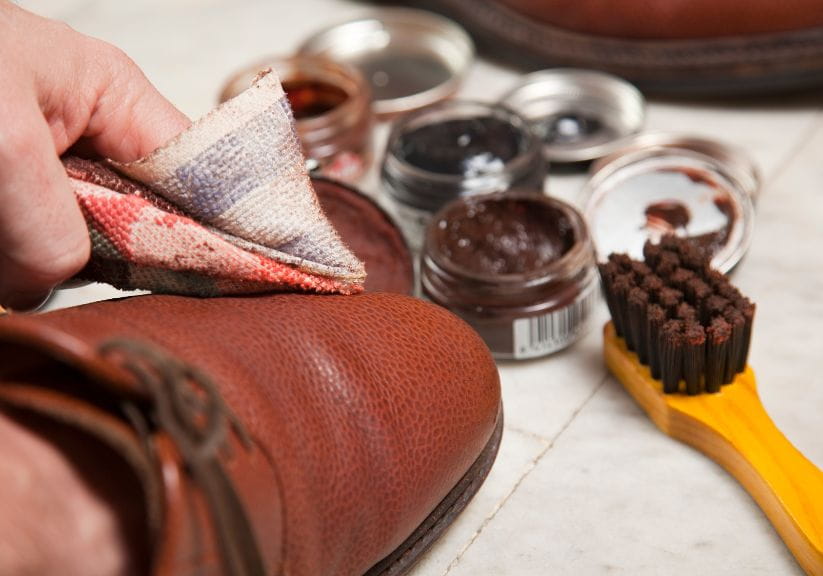 A person polishes leather shoes with leather polish