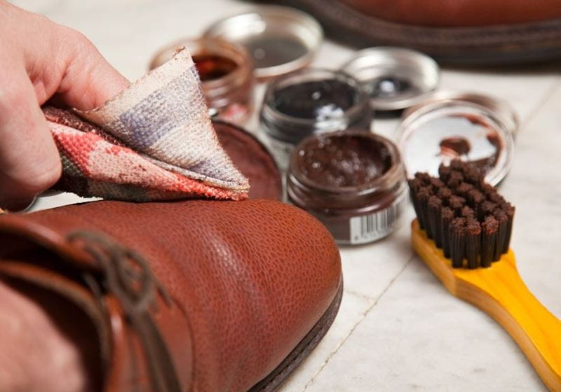 A person polishes leather shoes with leather polish