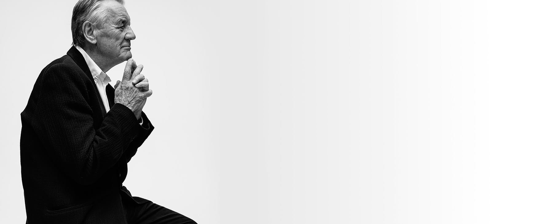 Michael Palin sat down with his hands clasped under his chin pensively