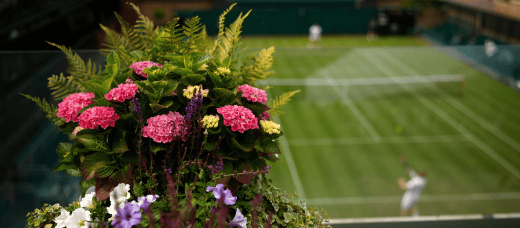 A bouquet of flowers in the forefront of a view of centre court at Wimbledon