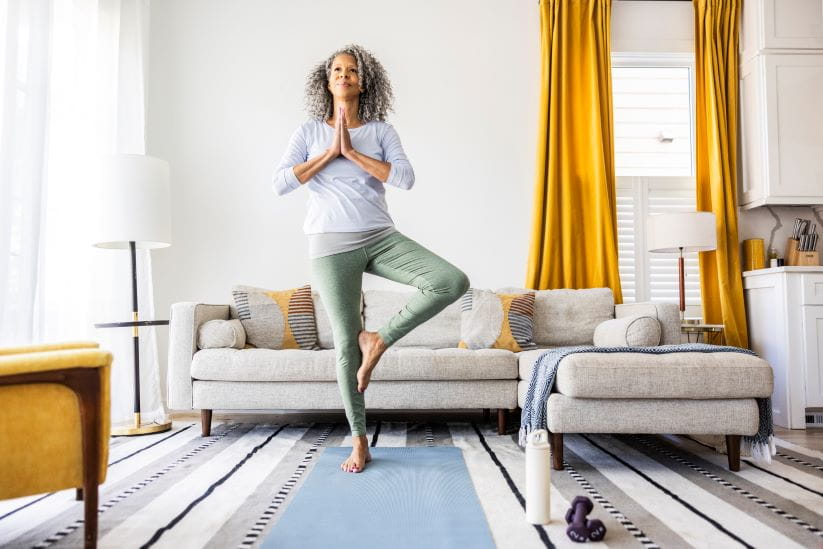 Woman doing tree pose in the lounge