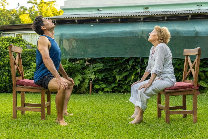 woman sat on the chair doing cat cow