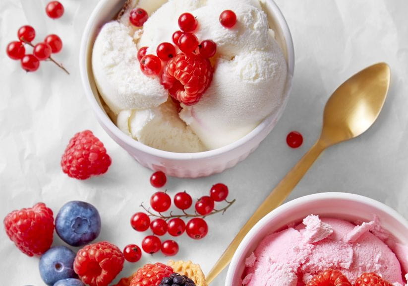 Ice cream in a small ramekin dish with fruit on the top