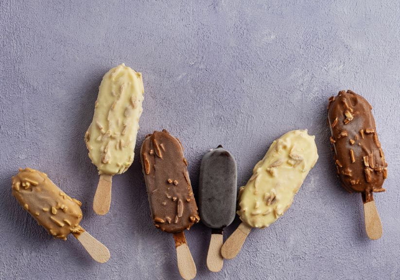Six different types of Magnum style ice creams on a stick