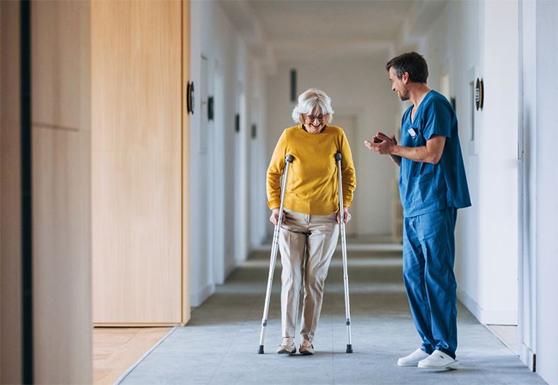 A nurse laughing with a woman after her successful surgery