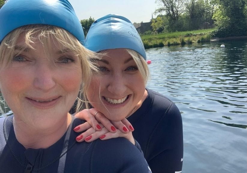 Miranda Richardson and Maggie Service in wetsuits and swimming hats at a lake