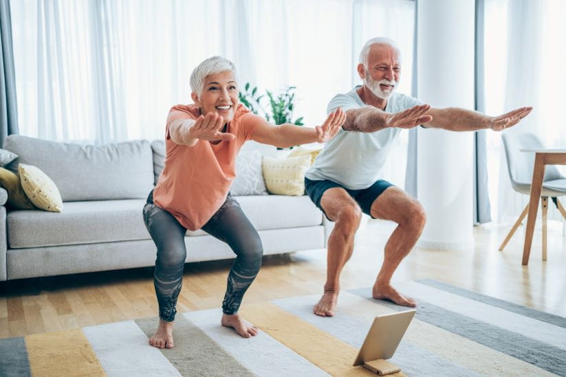 man and woman doing a squat in their lounge