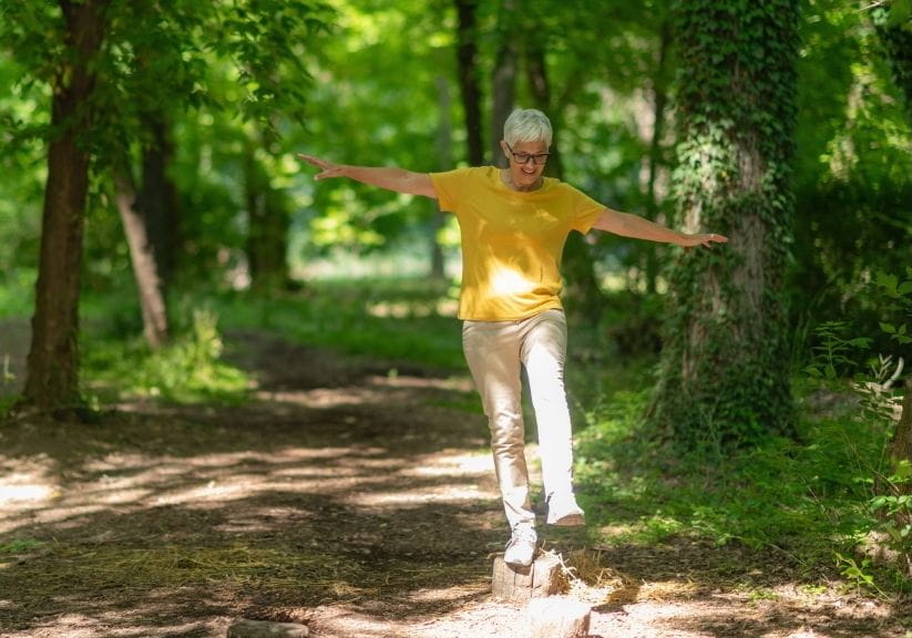a woman out on a walk balancing on some logs