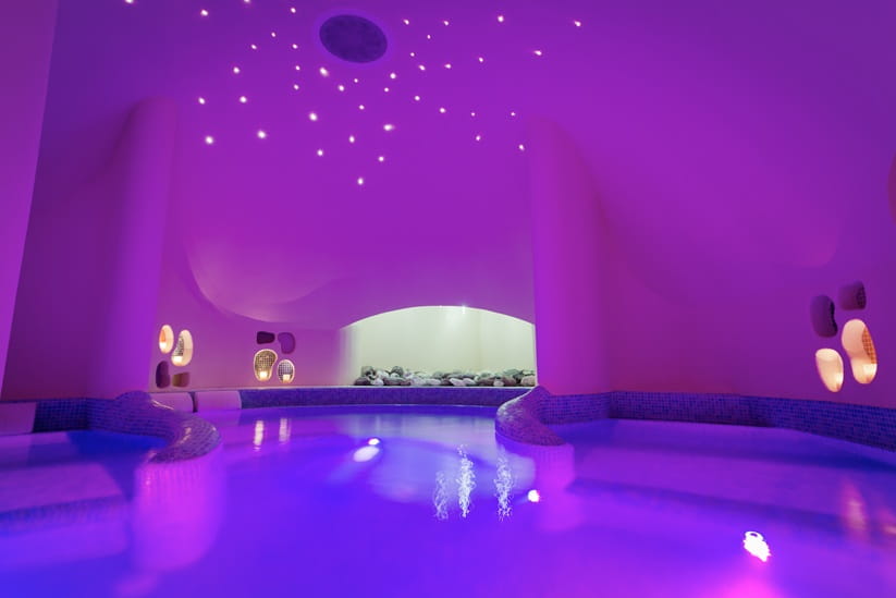 Spa pool with purple lighting and candles