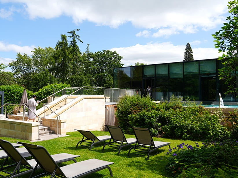 Spa hotel outdoor area with sunbeds and views of the gardens