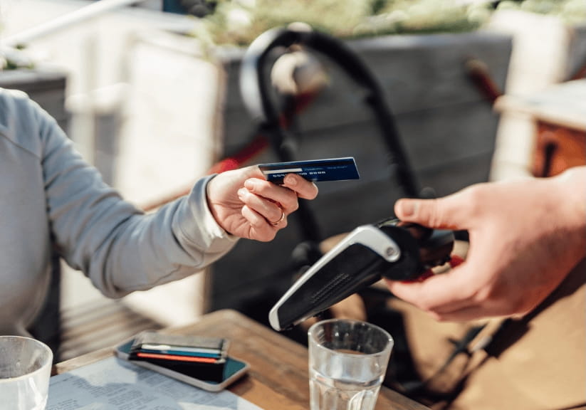 A close up of a person paying by credit card in a restaurant